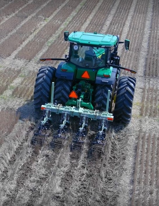 A tractor tilling a field.